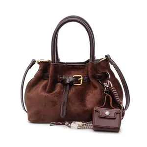 Bolso tipo cubo de gamuza café oscuro con correa de cuero y hebilla dorada