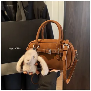 Brown vintage Boston bag detail with plush bunny charm and adjustable shoulder strap