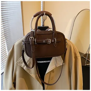 Detailed shot of dark brown vintage square bag with decorative strap and twin handles