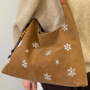 Brown faux suede hobo bag with white snowflake embroidery and wooden bead charm for women