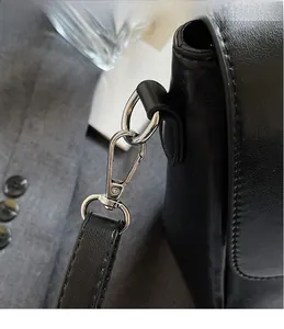 Close-up of durable silver metal swivel hook and premium black leather strap detail