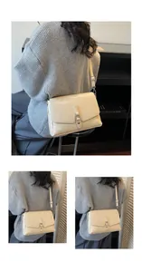 Detail view of a cream crossbody bag with silver hardware and adjustable strap on a model