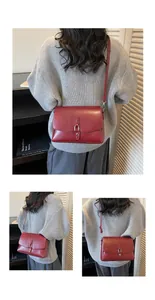 Macro detail of red leather crossbody bag with silver buckle and fine grain texture