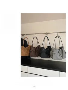 Dettaglio di quattro borse tote minimaliste nei colori kaki, marrone, nero e grigio