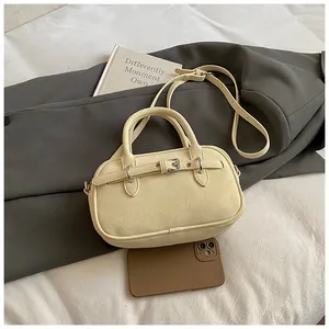 Macro view of beige textured small square bag with strap and buckle detail