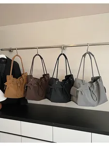 Dettaglio di quattro grandi borse tote in pelle in cammello, marrone, nero e grigio con stelle