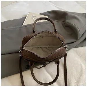 Detailed top view of brown leather handbag interior with light beige fabric lining