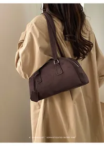 Chic dark chocolate bowling bag on model showing minimalist retro shoulder carry style