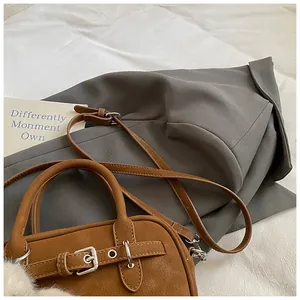 Detailed macro of brown lychee grain leather handbag with silver metal buckle and soft charm