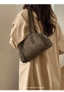 Detailed retro vibe of a dark brown suede bowling bag worn with a beige trench coat
