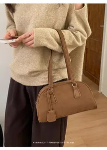 Detail of dark brown suede hobo bag shown with minimalist retro vibe on female model