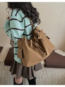 Dettaglio borsa tote in similpelle cammello con coulisse e ciondolo a forma di stella
