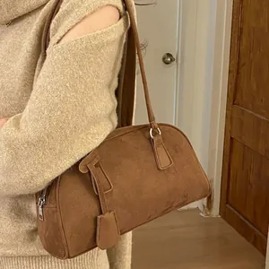 Brown suede bowling pillow bag with dual handles and metal zipper for women