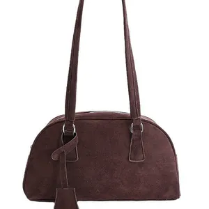 Minimalist dark brown suede bowling bag with dual shoulder straps and zipper closure