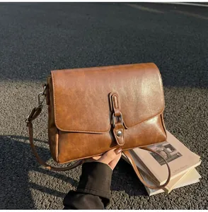 Detail of vintage caramel brown leather bag with silver metal clasp on stone road