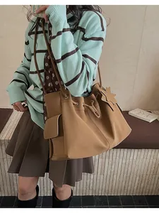 Dettaglio della borsa tote in pelle kaki con chiusura a coulisse e ciondolo a stella