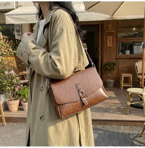 Classic brown leather crossbody bag featuring a refined metal clasp for stylish office wear