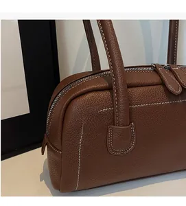 Dettaglio della pelle marrone con grana litchi e doppia cerniera della borsa bowling