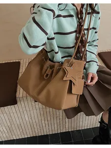 Dettaglio della borsa tote grande in pelle color cammello con coulisse e ciondolo a stella