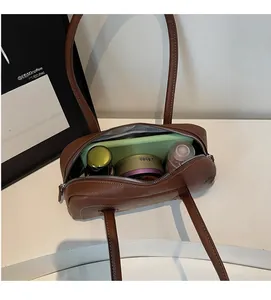 Vista dall'alto dell'interno spazioso di una borsa in pelle marrone con vari accessori