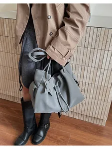 Dettaglio della borsa tote grigia in pelle con ciondolo a stella e coulisse