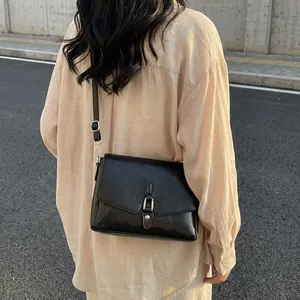 Minimalist black faux leather crossbody square bag with adjustable strap and metal buckle