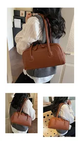 Borsa bowling in pelle martellata marrone con cuciture bianche mostrata in un contesto