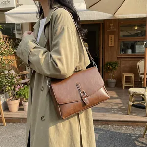 Retro caramel brown rectangular crossbody bag with vintage leather texture and silver hooks