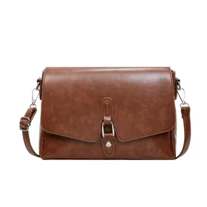 Minimalist brown vintage faux leather shoulder bag with silver buckle on white background