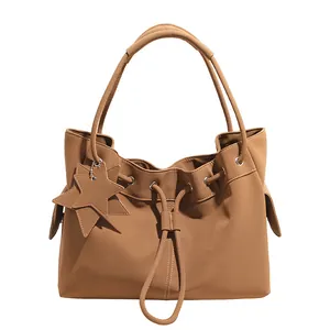 Borsa tote testurizzata marrone chiaro con coulisse e ciondoli a stella, vista a 45 gradi