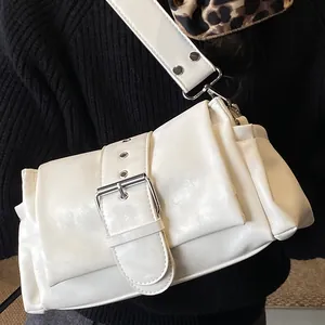 White PU leather baguette bag with large silver buckle and wide strap on model shoulder