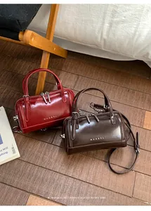 Détail des sacs Boston en cuir ciré brillant en rouge bordeaux et marron foncé