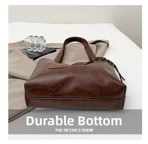 Vue macro d'un sac cabas marron foncé montrant le fond résistant et la texture du cuir rétro