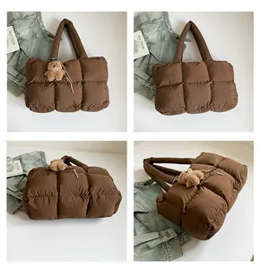 Λεπτομέρεια καφέ καπιτονέ τσάντα tote με υφή puffer και κρεμαστό αρκουδάκι