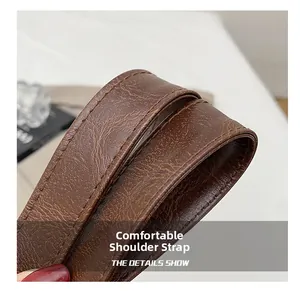 Vue macro d'une bandoulière en cuir marron avec coutures précises et grain de litchi