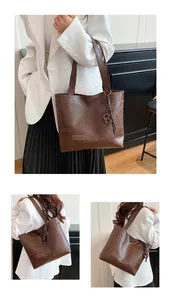 Vues détaillées d'un sac cabas en cuir marron avec lettrage FASHION et breloque