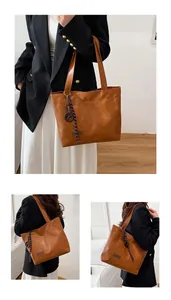 Détail d'un sac cabas marron avec texture cuir vintage et breloque étiquette mode