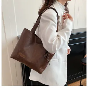 Détail du sac cabas marron foncé montrant la texture cuir PU souple et le patch mode