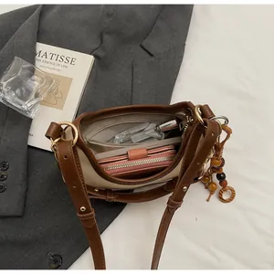 Detailed interior of vintage color-block handbag showing daily items like phone and perfume