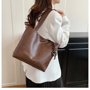 Sac fourre-tout marron en simili cuir avec étiquette FASHION porté par un mannequin