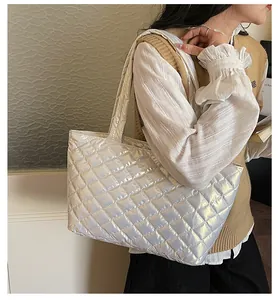 Side view of large iridescent silver quilted tote bag on model for casual wear