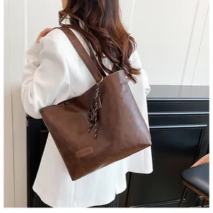 Gros plan du sac cabas en cuir marron avec nœud tressé et étiquette mode élégante