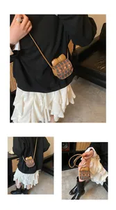 Detail of cute plaid crossbody bag with bow accent and flower charms on knit fabric