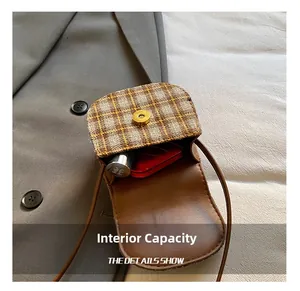 Internal capacity of mini checkered crossbody bag showing lipstick and leather details