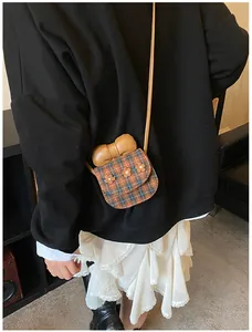 Cute mini checkered crossbody bag with 3D flower charms and bow detail shown on a model