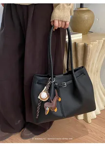 Detailansicht einer schwarzen Shopper aus Leder mit Hundeanhänger im Wohnzimmer
