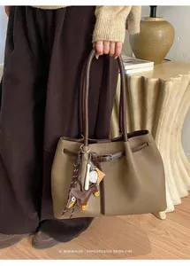 Detailansicht der Tragetasche mit Litschi-Lederstruktur und einem Dackel-Taschenanhänger
