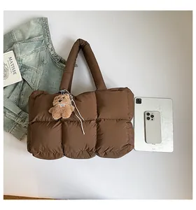Καπιτονέ τσάντα tote με αρκουδάκι δίπλα σε iPad και καθημερινά αξεσουάρ