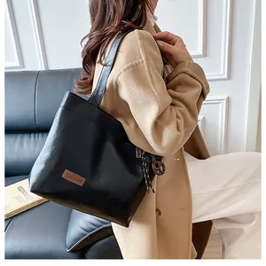 Détail du sac cabas en cuir noir avec étiquette fashion et finition texturée de qualité