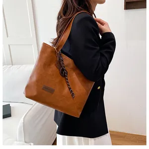 Détail du sac cabas en cuir PU marron avec ruban rayé et écusson de mode